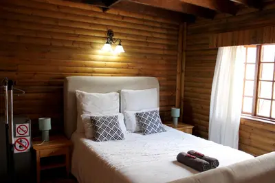 a bedroom with a bed in a log cabin at River Ridge Log Home - Inside Dinokeng Big 5 in Klipdrift