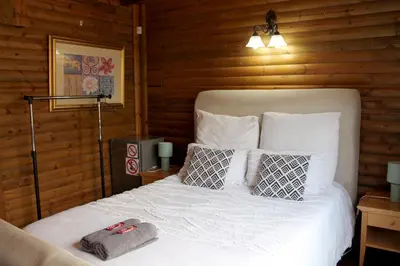 a bedroom with a white bed with pillows at River Ridge Log Home - Inside Dinokeng Big 5 in Klipdrift