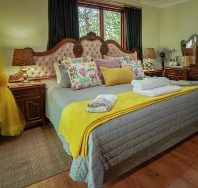 a bedroom with a large bed with colorful pillows at Wit Hangmat Bush Retreat in Sybrandskraal
