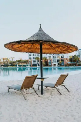 a table and two chairs under an umbrella on the beach at Playa Azul in Pretoria