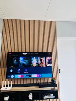 a large flat screen tv on a wooden wall at Playa Azul in Pretoria