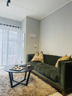 a living room with a green couch and a table at Playa Azul in Pretoria