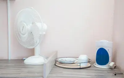 a white fan sitting on top of a wooden floor at Emmanuel Guesthouse in Witbank