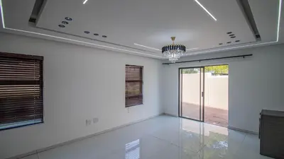 a white room with a large window and a chandelier at Away like Home in Midrand