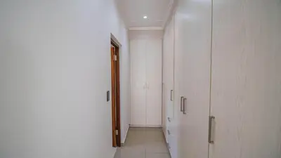 a hallway with white walls and a hallway with cabinets at Away like Home in Midrand