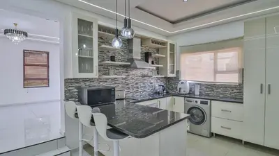 a kitchen with a table and chairs in a room at Away like Home in Midrand