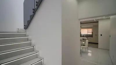 a staircase leading to a dining room with a table at Away like Home in Midrand
