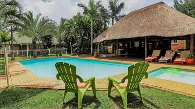two green chairs sitting next to a swimming pool at Hoogland Spa Resort Bela Bela in Bela-Bela