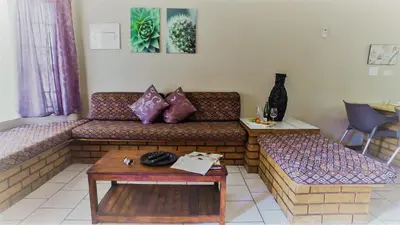 a living room with a couch and a table at Hoogland Spa Resort Bela Bela in Bela-Bela