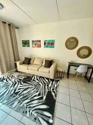 a living room with a couch and a table at Waterfall Smart Apartment in Midrand