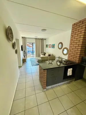 a room with a kitchen and a living room at Waterfall Smart Apartment in Midrand