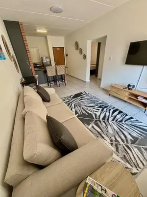 a couch in a living room with a zebra rug at Waterfall Smart Apartment in Midrand