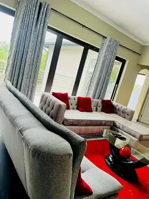 a living room with two couches in front of windows at The Perazim Place at 222 Sabie River Eco-Estate in Hazyview