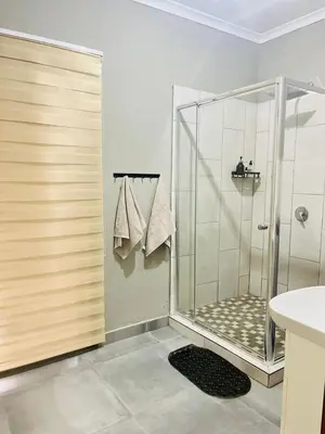 a bathroom with a shower with a glass door at The Perazim Place at 222 Sabie River Eco-Estate in Hazyview