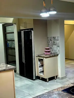 a kitchen with a black refrigerator in a room at The Perazim Place at 222 Sabie River Eco-Estate in Hazyview
