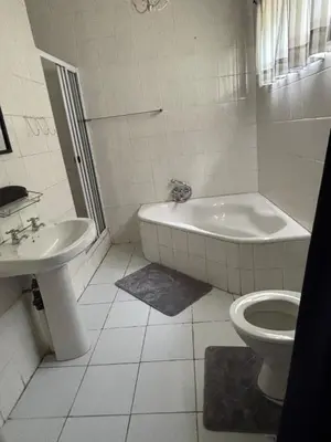 a bathroom with a tub and a toilet and a sink at Marie Guest House in Polokwane