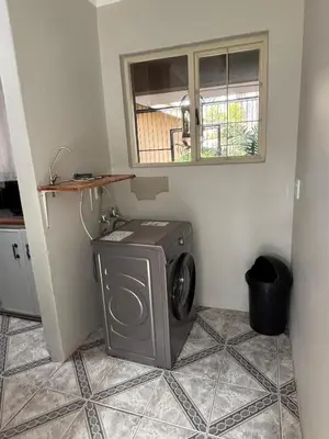a washing machine in a room with a window at Marie Guest House in Polokwane