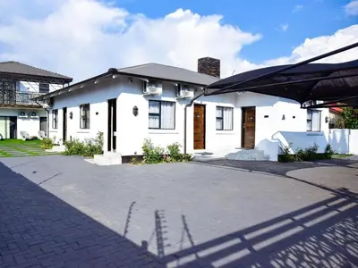 a white house with a driveway in front of it at C'est La Vie Guest House in Witbank