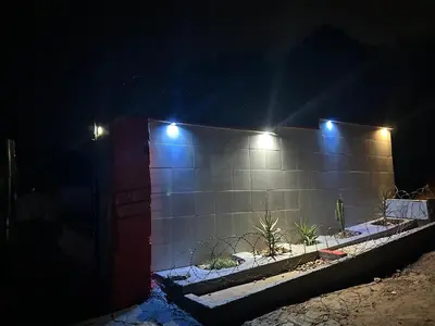 a brick wall with lights on it at night at Lakeboutiquehotel empire new in Thohoyandou