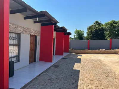 a building with red doors and a fence at Lakeboutiquehotel empire new in Thohoyandou