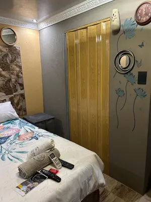 a bedroom with a bed with remote controls on it at Lakeboutiquehotel empire new in Thohoyandou