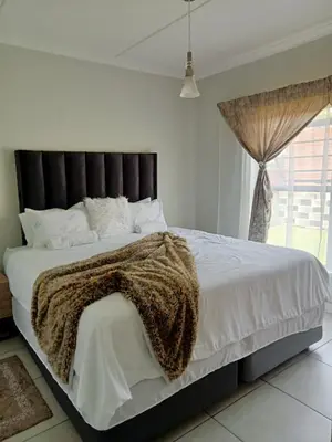 a bedroom with a large bed with a brown blanket at kaso holidays at the Blyde in Pretoria