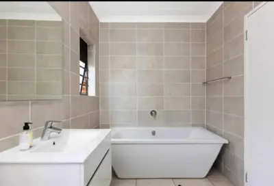 a bathroom with two sinks and a bath tub at kaso holidays at the Blyde in Pretoria