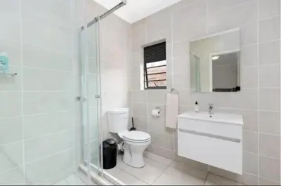a white bathroom with a toilet and a sink at kaso holidays at the Blyde in Pretoria