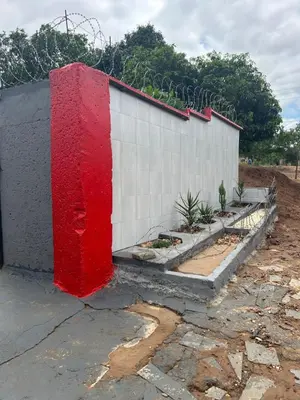 a building with red paint on the side of it at Lake boutique hotel empire in Thohoyandou