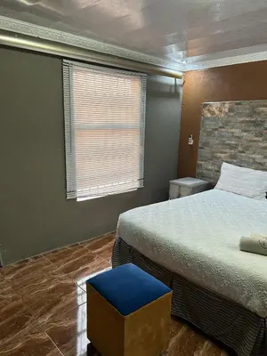 a bedroom with two beds and a blue stool at Lake boutique hotel empire in Thohoyandou