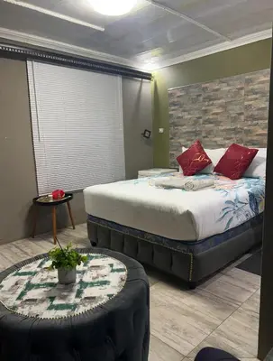 a bedroom with a large bed with red pillows at Lake boutique hotel empire in Thohoyandou