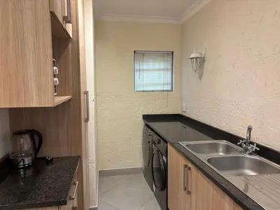 a small kitchen with a sink and a dishwasher at Glen Gory stay in Benoni