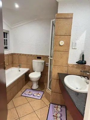 a bathroom with a toilet and a tub and a sink at Glen Gory stay in Benoni