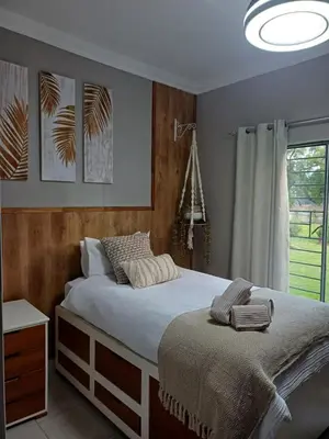 a bedroom with a bed and a window at Blessings is a home with Cozy Charms in Pretoria