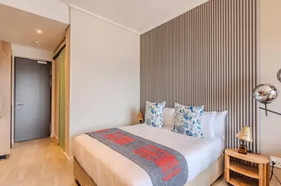 a bedroom with a large bed with blue pillows at Menlyn Maine in Pretoria