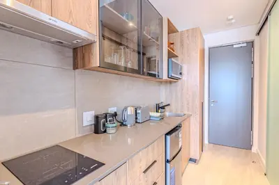 a kitchen with wooden cabinets and a counter top at Menlyn Maine in Pretoria