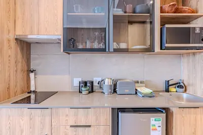 a kitchen with wooden cabinets and a counter top at Menlyn Maine in Pretoria
