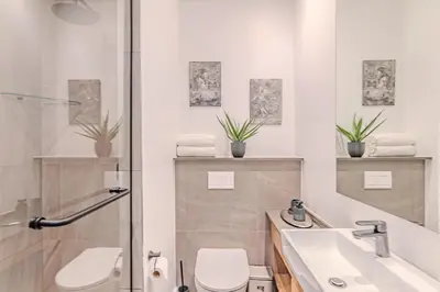 a bathroom with a toilet and a sink and a shower at Menlyn Maine in Pretoria