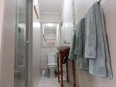 a bathroom with a toilet and a shower with towels at Joy Haven - Cottage in Centurion