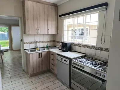 a kitchen with a sink and a stove top oven at Joy Haven - Cottage in Centurion