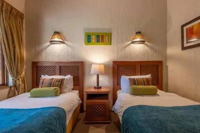 a bedroom with two beds and a table with a lamp at Kruger Park Lodge Unit No 237 in Hazyview