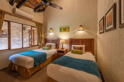 two beds in a room with windows at Kruger Park Lodge Unit No 237 in Hazyview