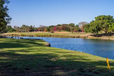 a golf course with a lake in the foreground at Kruger Park Lodge Unit No 237 in Hazyview