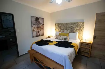 a bedroom with a large bed in a room at Manor by My Adventure House in Marloth Park