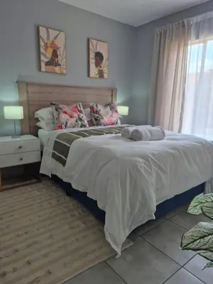 a bedroom with a large bed and a window at Mlangeni's Rest in Centurion
