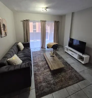 a living room with a couch and a flat screen tv at Mlangeni's Rest in Centurion