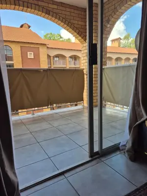 a view of a courtyard from a patio door at Mlangeni's Rest in Centurion