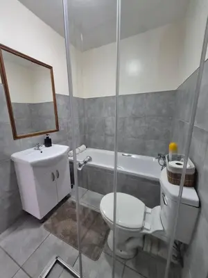 a bathroom with a toilet and a sink and a shower at Mlangeni's Rest in Centurion