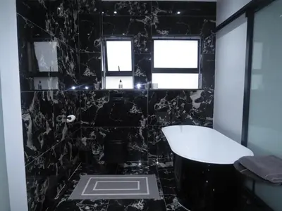 a black bathroom with a tub and a window at Thaba Bosiu Villa in Naboomspruit