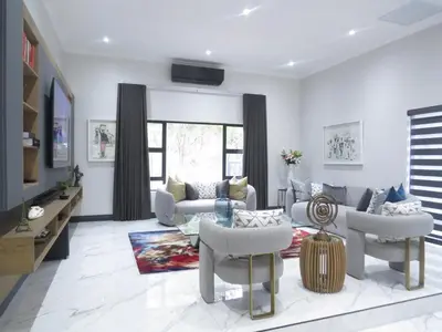 a living room with couches and chairs and a tv at Thaba Bosiu Villa in Naboomspruit